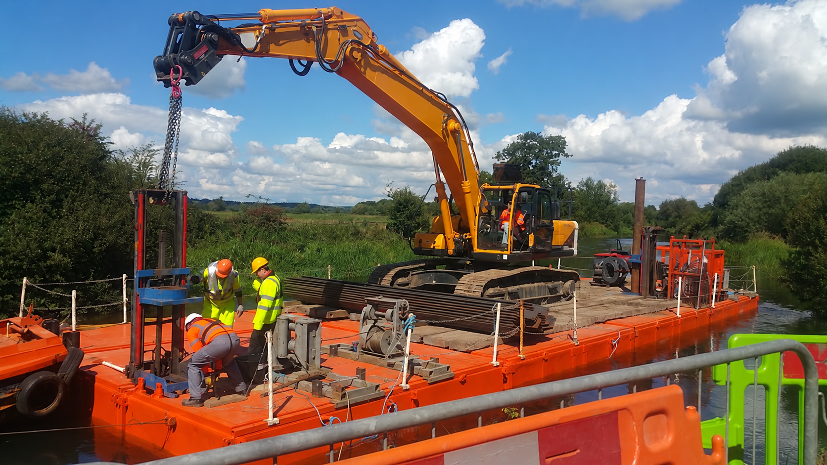 Excavator and workers on a modular pontoon working on a waterway